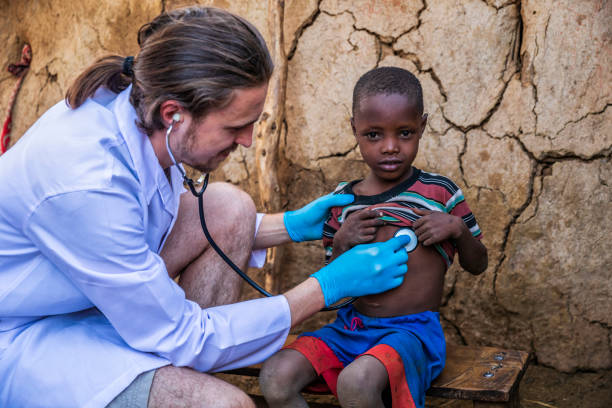Doctor examining little African boy in small Masai village, Southern Kenya. Maasai tribe inhabiting southern Kenya and northern Tanzania, and they are related to the Samburu.